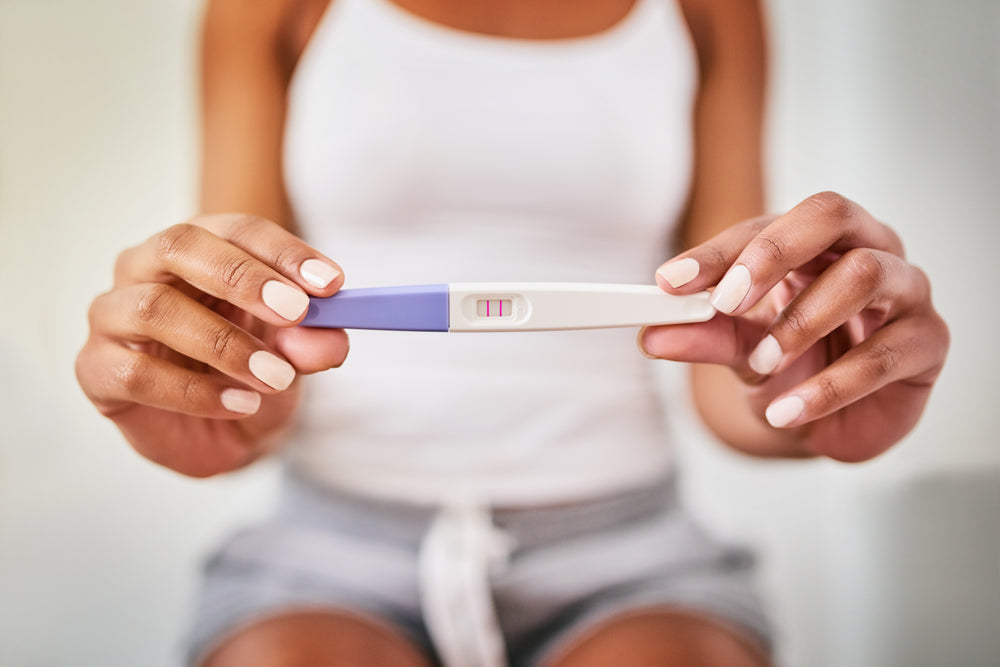  Woman holding positive pregnancy test 